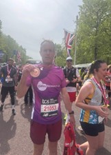 Marathon runner holding a medal, UK flag visible.