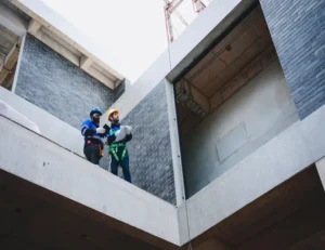 Construction workers reviewing building plans on-site.