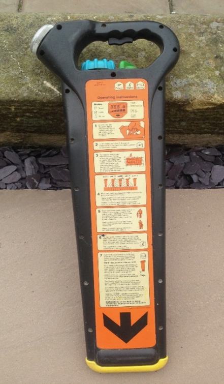 Metal detector with operating instructions and handle view.